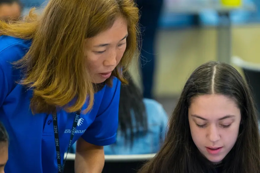 Un enseignant aide une élève au CyberDay4Girls