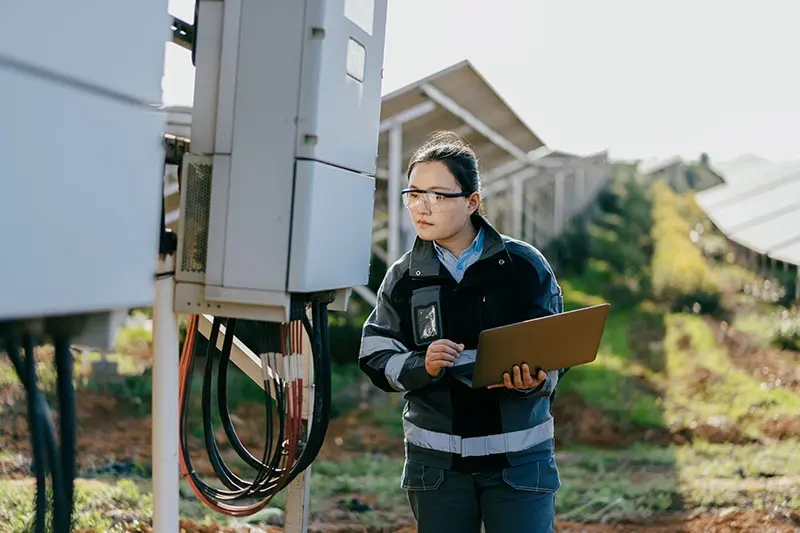 Asiatische Ingenieurin arbeitet in einem Solarkraftwerk