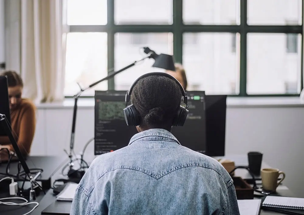 Mujer joven frente a un monitor en la oficina